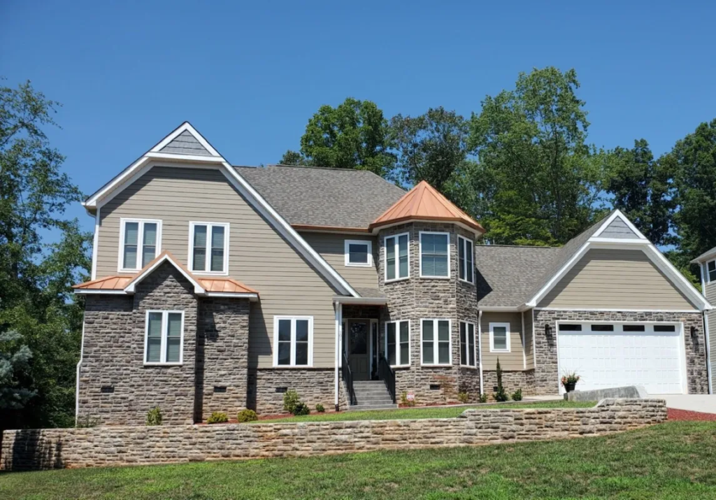 A custom built home with a garage and a driveway featuring roofing and siding in Hickory, NC.